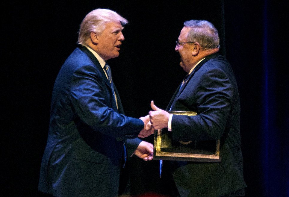 Trump greets LePage at a rally. LePage later advocated "authoritarian power."
