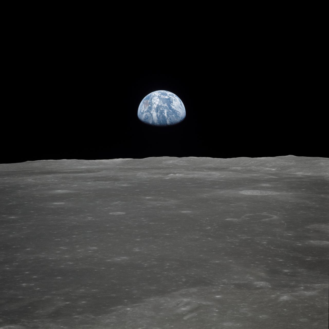 AS11-44-6552 (16-24 July 1969) --- This view of Earth rising over the moon's horizon was taken from the Apollo spacecraft. The lunar terrain pictured is in the area of Smyth's Sea on the nearside. Coordinates of the center of the terrain are 85 degrees east longitude and 3 degrees north latitude. While astronaut Neil A. Armstrong, commander; and Edwin E. Aldrin Jr., lunar module pilot, descended in the Lunar Module (LM) "Eagle" to explore the Sea of Tranquility region of the moon, astronaut Michael Collins remained with the Command and Service Modules (CSM) "Columbia" in lunar orbit.